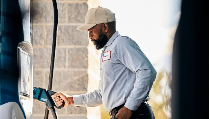 A driver plugging in a Volvo VNY Electric